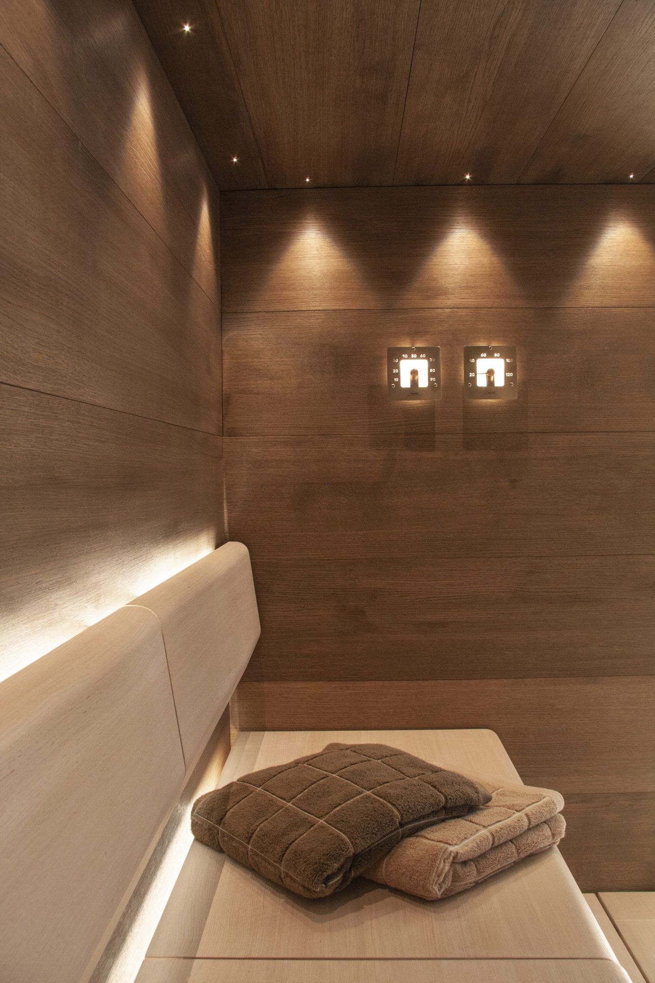 Cariitin Taive sauna linear ledeillä, kuidut katossa ja valaistut mittarit seinässä.
